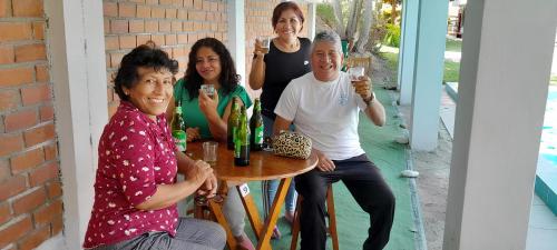 un grupo de personas sentadas alrededor de una mesa con bebidas en Hotel Quilla Wasi, en Lunahuaná