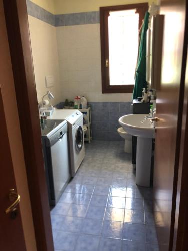 een badkamer met een wasmachine en een wastafel bij Freedom Garden in Vedelago