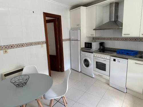 a kitchen with a white table and a table and chairs at Preciosa casa en Castro Urdiales in Castro-Urdiales