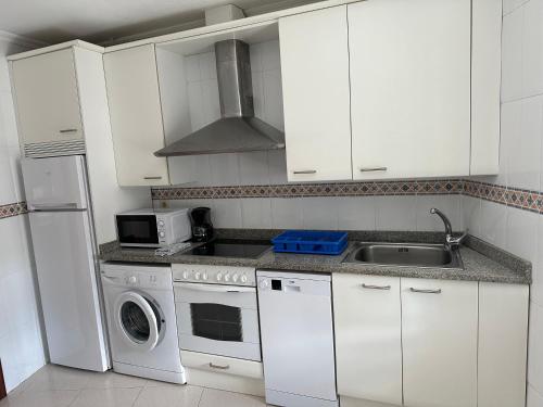 uma cozinha branca com um lavatório e um micro-ondas em Preciosa casa en Castro Urdiales em Castro-Urdiales