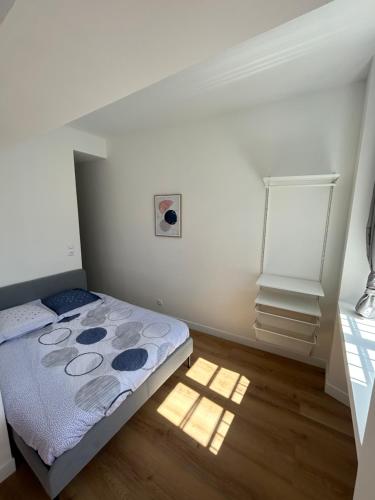 une chambre avec un lit dans une pièce blanche dans l'établissement Joyau historique 101, à Aurillac