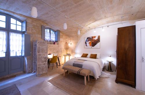 une chambre avec un lit et une table dans une pièce dans l'établissement La DAME de FLAUX, à Uzès