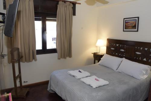 ein Schlafzimmer mit einem Bett mit zwei Handtüchern darauf in der Unterkunft Departamento Balcarce Jujuy 4B in San Salvador de Jujuy