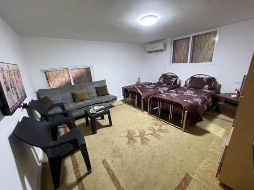 Um QeisにあるBeit Al Hasan بيت الحسنのリビングルーム(ベッド1台、ソファ付)