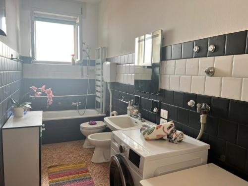 La salle de bains est pourvue d'un lavabo, de toilettes et d'une baignoire. dans l'établissement Bnbook Trilo Malpensa, à Cardano al Campo