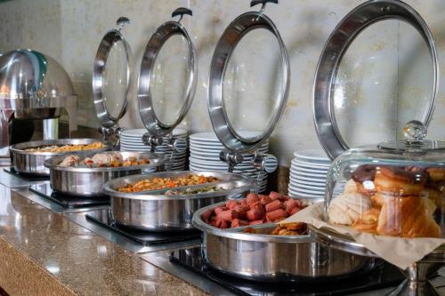 a buffet line with trays of food in pans at Fiesta Inn Playa del Carmen in Playa del Carmen