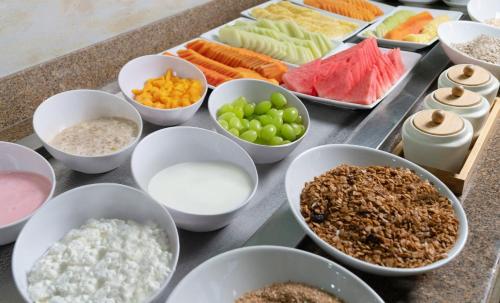 a table topped with bowls of different types of food at Fiesta Inn Playa del Carmen in Playa del Carmen