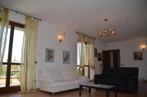 a living room with a white couch and a table at Villa Patrizia in Moncalvo