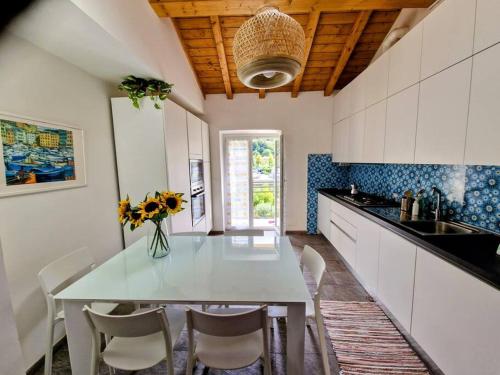 une cuisine avec une table blanche, des chaises et un comptoir dans l'établissement ALL NEW and AIR-CONDITIONED La GRAZIOSA apartment, à Gênes