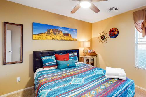 a bedroom with a bed with a mountain painting on the wall at Gold Canyon Getaway in Gold Canyon