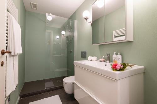 a bathroom with a white sink and a toilet at Isola Bella Apartments Via Stretta in Stresa