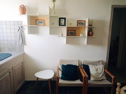 - une cuisine avec 2 chaises et des oreillers bleus dans l'établissement Maison de village, charmante et authentique, haute-corse, à Vezzani