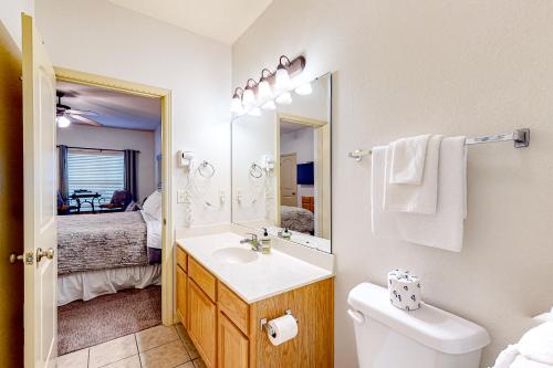 a bathroom with a sink and a toilet and a mirror at Wildwood Adventures - Unit B in Branson