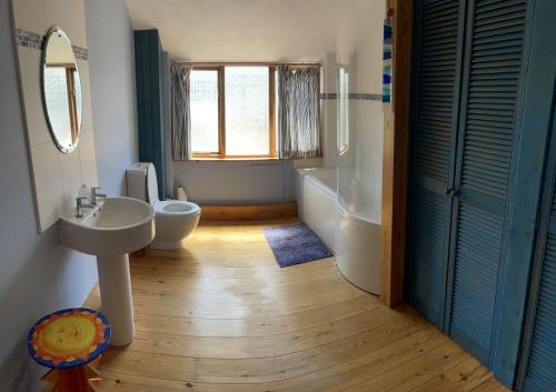 a bathroom with a sink and a toilet and a tub at The Old Barn in St Ives