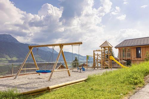 a playground with a slide and a swing at Bergresort Hauser Kaibling by ALPS RESORTS in Haus im Ennstal