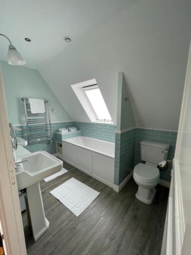 uma casa de banho com um lavatório, uma banheira e um WC. em Les Cottages du Manoir, Jacuzzi -Crozon em Crozon