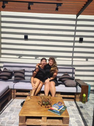 two women are sitting on a couch at Casa Agustina in Cusco