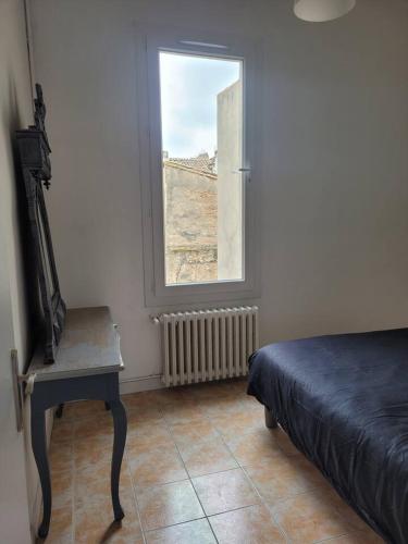 une chambre avec un lit et une fenêtre dans l'établissement Appartement Morgand, à Narbonne