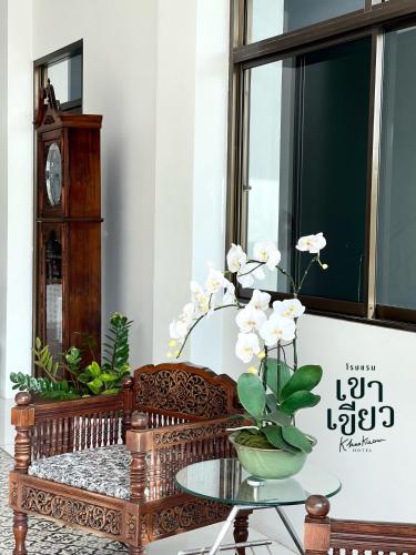 a living room with a bench and a glass table at KHAO KIEOW Hotel โรงแรมเขาเขียว 