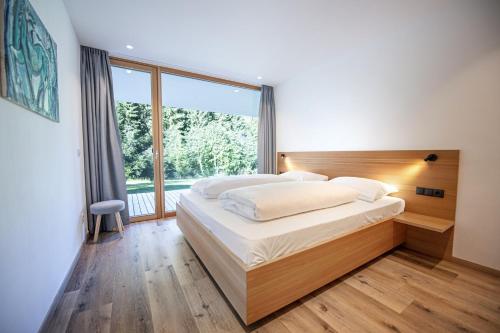 a bedroom with a large bed and a large window at Greva Apartments 1 in Santa Cristina in Val Gardena