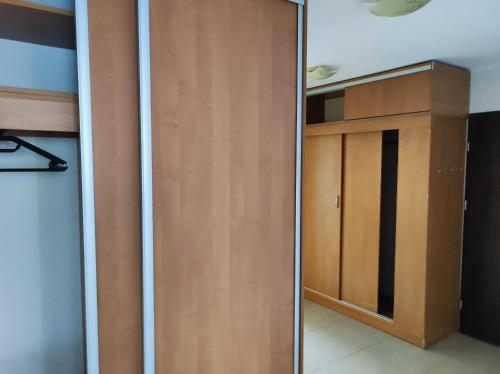 Habitación con armario y puerta de madera. en Apartament na Wyszyńskiego - Noclegi, mieszkanie dla firm i pracowników, en Myszków