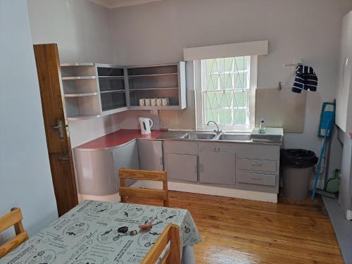 a small kitchen with a table and a sink at Blye Uitsig in Oudtshoorn