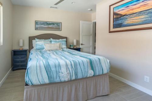 a bedroom with a bed and a painting on the wall at Coronado Bayside Charmer in San Diego