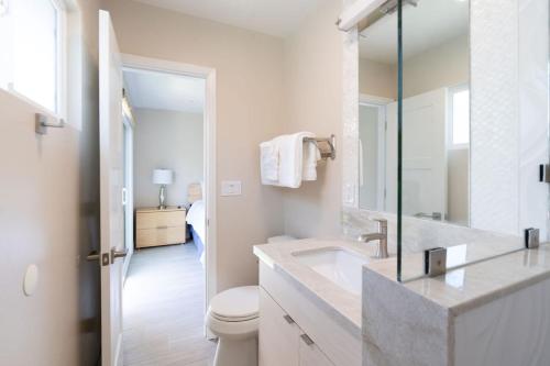 a white bathroom with a sink and a toilet at Coronado Bayside Charmer in San Diego