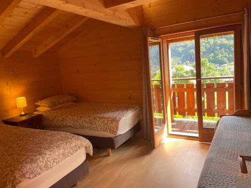 a bedroom with two beds and a large window at Chalet Belle Folie in Saint-Jean-d'Aulps