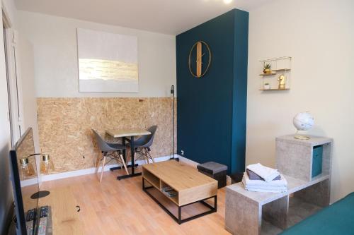 un salon avec un mur bleu et une table dans l'établissement Le Jockey - SIPCO Immobilier - Centre, à Saint Lo