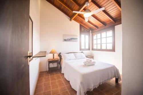 1 dormitorio con 1 cama y ventilador de techo en Casa na Barra de Ibiraquera en Barra de Ibiraquera