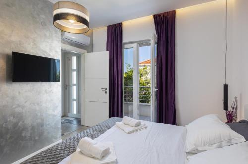 - une chambre avec 2 lits blancs et une télévision dans l'établissement Gjenero, à Dubrovnik
