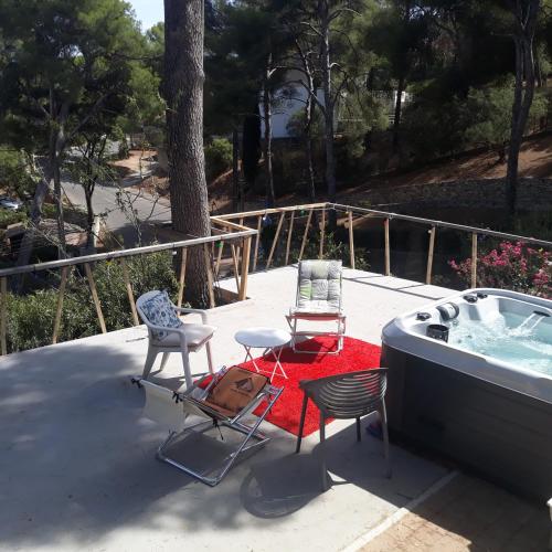 een patio met 2 stoelen en een hot tub bij Villa Nicole in Carry-le-Rouet