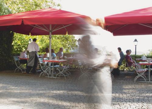 a woman is walking under a red umbrella at Gasthaus Schlosshalde in Winterthur