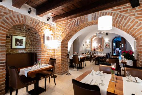 restauracja ze stołami i krzesłami oraz ceglaną ścianą w obiekcie Hotel Rubinstein w Krakowie