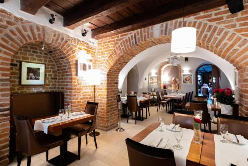 un restaurante con mesas y sillas y una pared de ladrillo en Hotel Rubinstein, en Cracovia