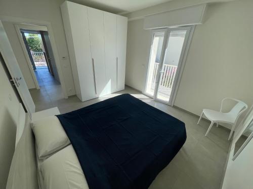 a bedroom with a bed with a blue blanket on it at Villa Primule Cattolica in Cattolica