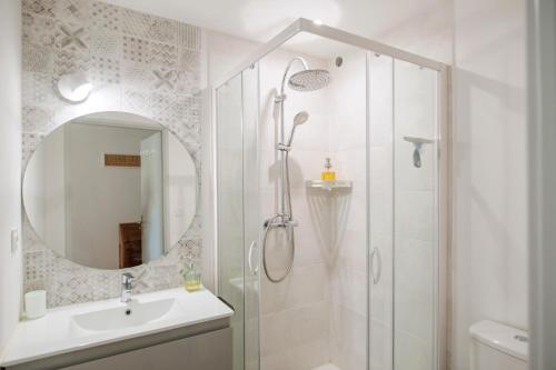 a bathroom with a shower and a sink and a mirror at Le Solaret in Sète