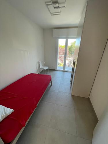a bedroom with a red bed and a window at Villa Primule Cattolica in Cattolica