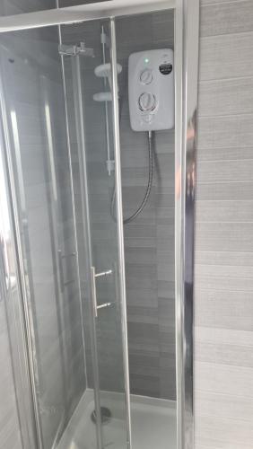a shower with a glass door in a bathroom at Ravenhill Townhouse Belfast in Belfast