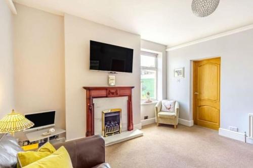 a living room with a fireplace and a tv on the wall at Bewick House Large three bedroom Sleeps upto six in Newbiggin-by-the-Sea