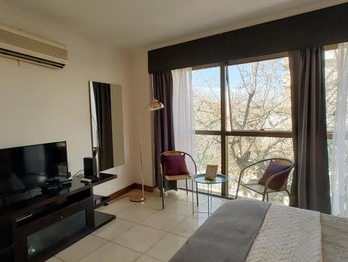 a bedroom with a bed and a large window at MENDOZA Suites 11 in Mendoza