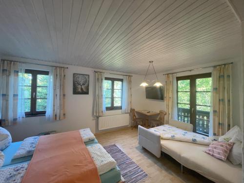 a bedroom with two beds and a couch and windows at Farmreiterhof in Pruggern