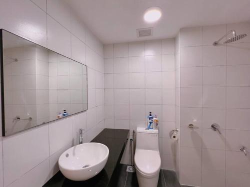 uma casa de banho com um WC, um lavatório e um espelho. em Comfy & Cozy Chambers KL, Near PWTC & Sunway Putra Mall em Kuala Lumpur