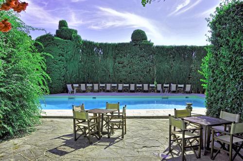 a patio with tables and chairs next to a pool at Castello di Montegufoni by PosarelliVillas in Montagnana Val di Pesa