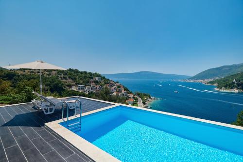 a swimming pool with a view of the water at Villa Bojana in Tivat