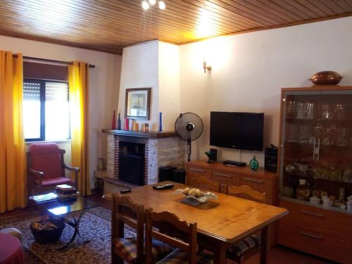 een woonkamer met een tafel en een televisie bij A casinha in Cerejeiras