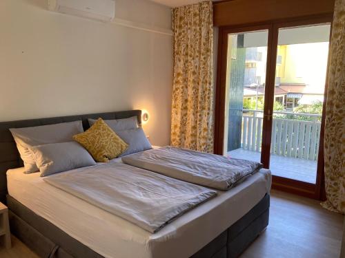 ein großes Bett in einem Zimmer mit Fenster in der Unterkunft Grado-Pineta a Mare in Grado-Pineta