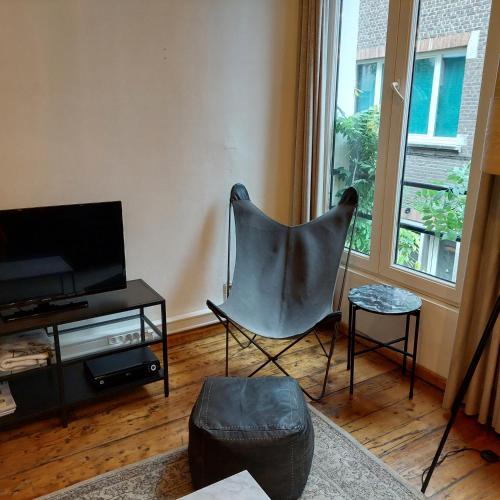 a living room with a chair and a television at Huize Amoras in Antwerp