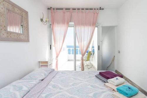 Schlafzimmer mit einem Bett mit rosa Vorhängen und einem Fenster in der Unterkunft Casa el Mar Cueva y vista bonita in Lomo de Mena